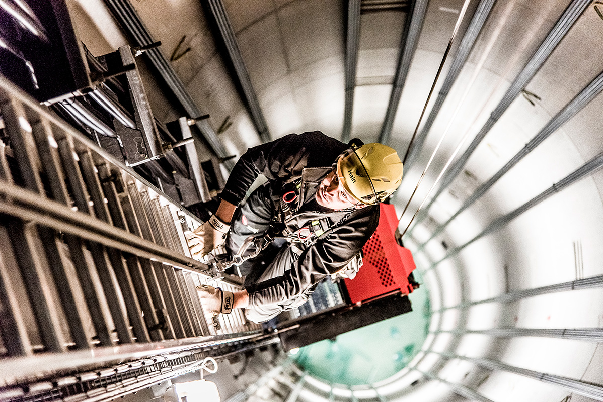 Servicetechniker mit Sicherheitsausrüstung in einer Windkraftanlage