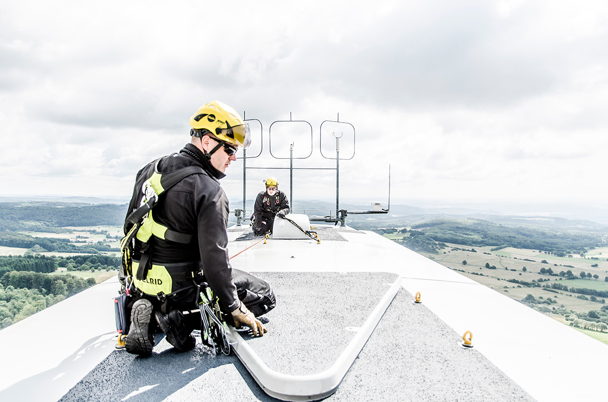 Servicetechniker mit Absturzsicherung auf der Gondel einer Windkraftanlage