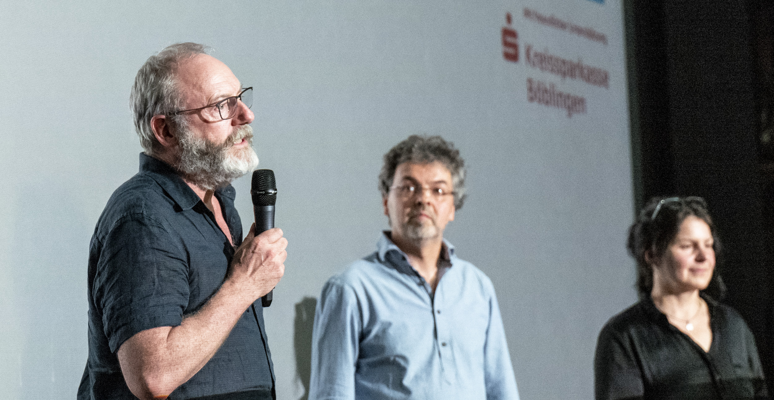 Liam Cunningham spricht mit Mikrofon auf der Bühne während einer